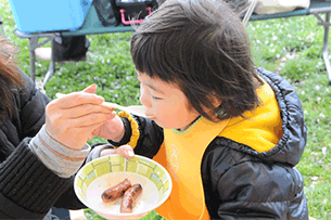 ソーセージを食べるお子さん